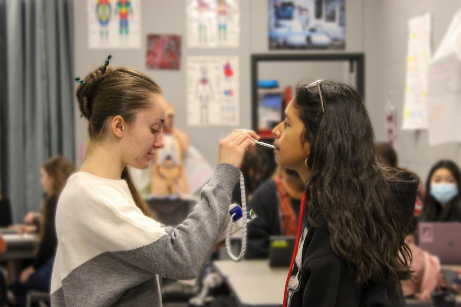Medical Assisting students in Nurse Venners CTE class practice taking each others temperatures.
