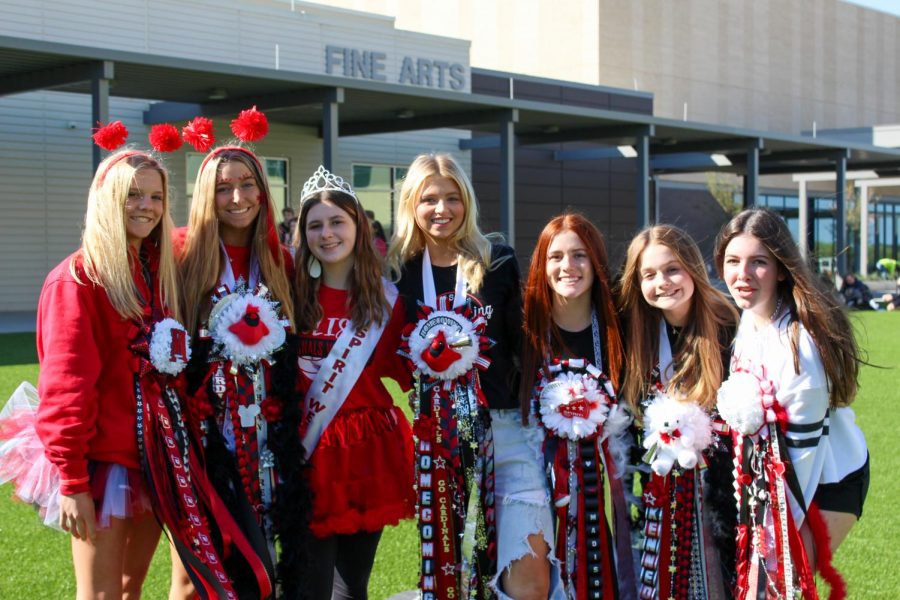 Students display their Cardinal spirit wear and mums during Homecoming Week 2021.