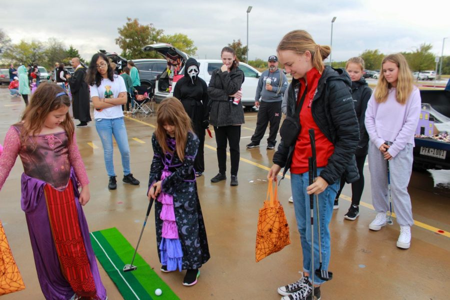 Senior golf athlete Leslie Bauslaugh coaches young Cardinals in a putt putt game at FCAs Trunk or Treat event held Oct. 29.