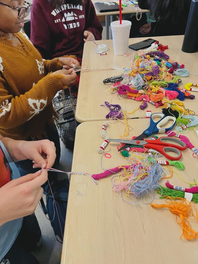 Students make string friendship bracelets during Mega Lunch Bracelet Club.
