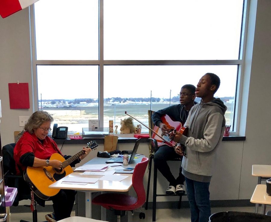 Mrs. Hernandez plays guitar with students during her Mega Lunch club Life Enrichment.