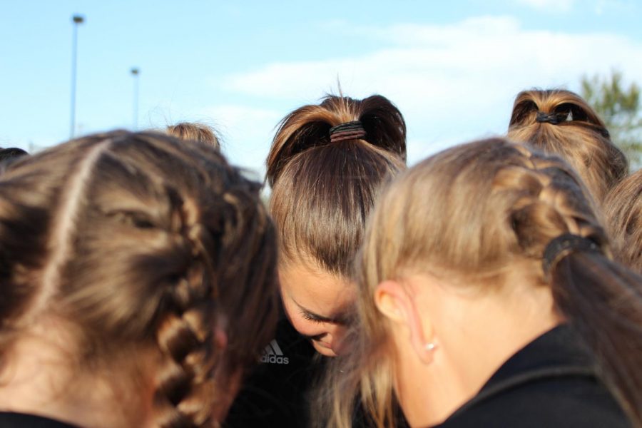 Girls+cross+country+huddles+together+before+a+meet+to+ask+for+strength.