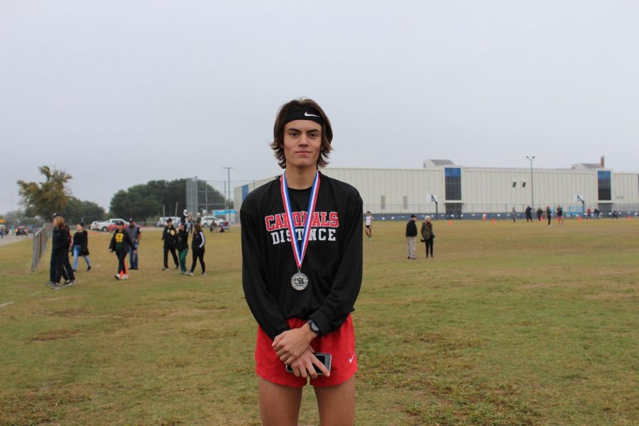 Junior Lucas Tauch shows off his second place medal, which qualifies him for the state meet.