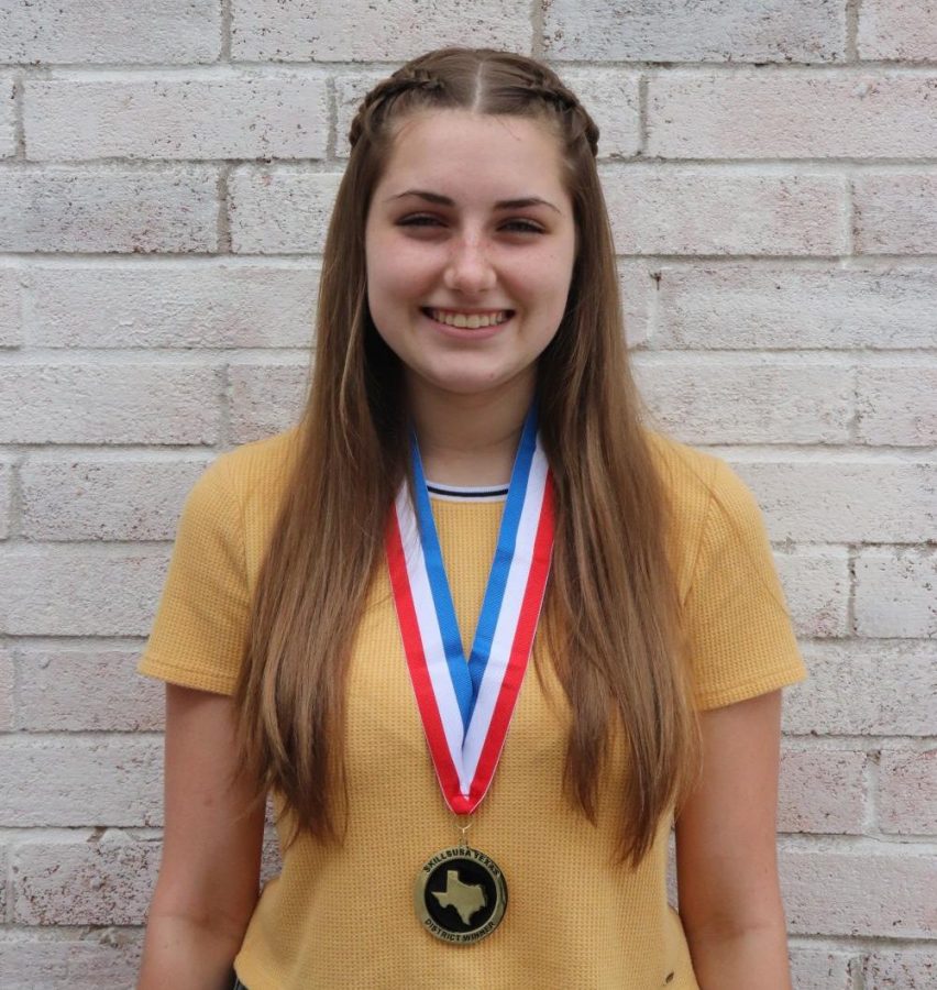 Junior Taylor Hendrickson poses with her medal after winning first place at the district SkillsUSA contest in cosmetology.