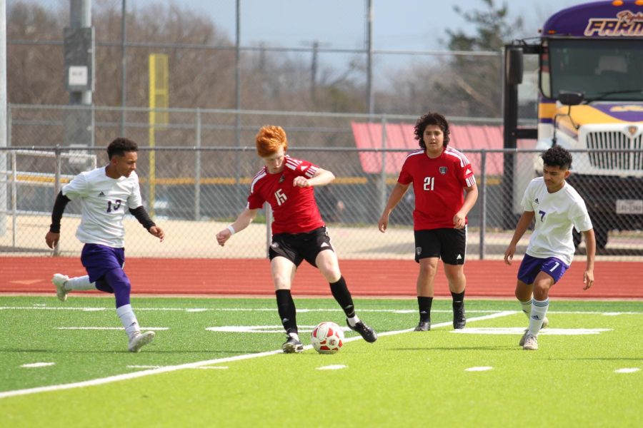 Junior Canyon Power dribbles the ball with junior Aidan Pintor watching. The Cardinals defeated Farmersville, 7-1, on March 5. They take on Sunnyvale for the bi-district title on March 25 at Lovejoy High School after the Lady Cards game, which starts at 6 p.m.