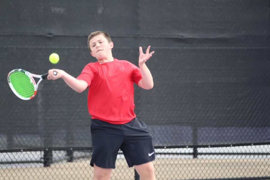 Sophomore Cade Gentry prepares to hit the ball in one of his district tennis matches on March 30. Cade won the gold medal and qualified for the regional tournament along with four other teammates.
