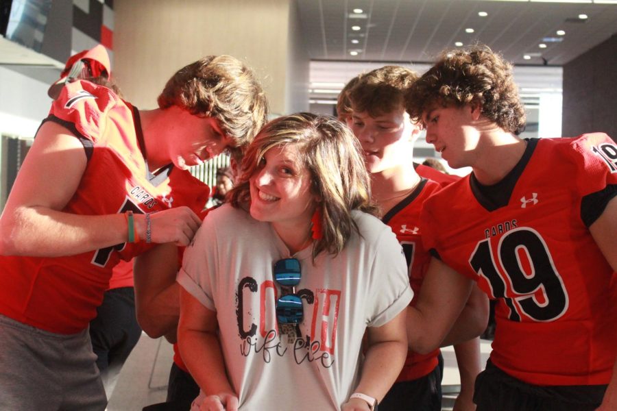Varsity football players autograph Mrs. Nallys shirt during Meet the Cardinals Night held Aug. 13.