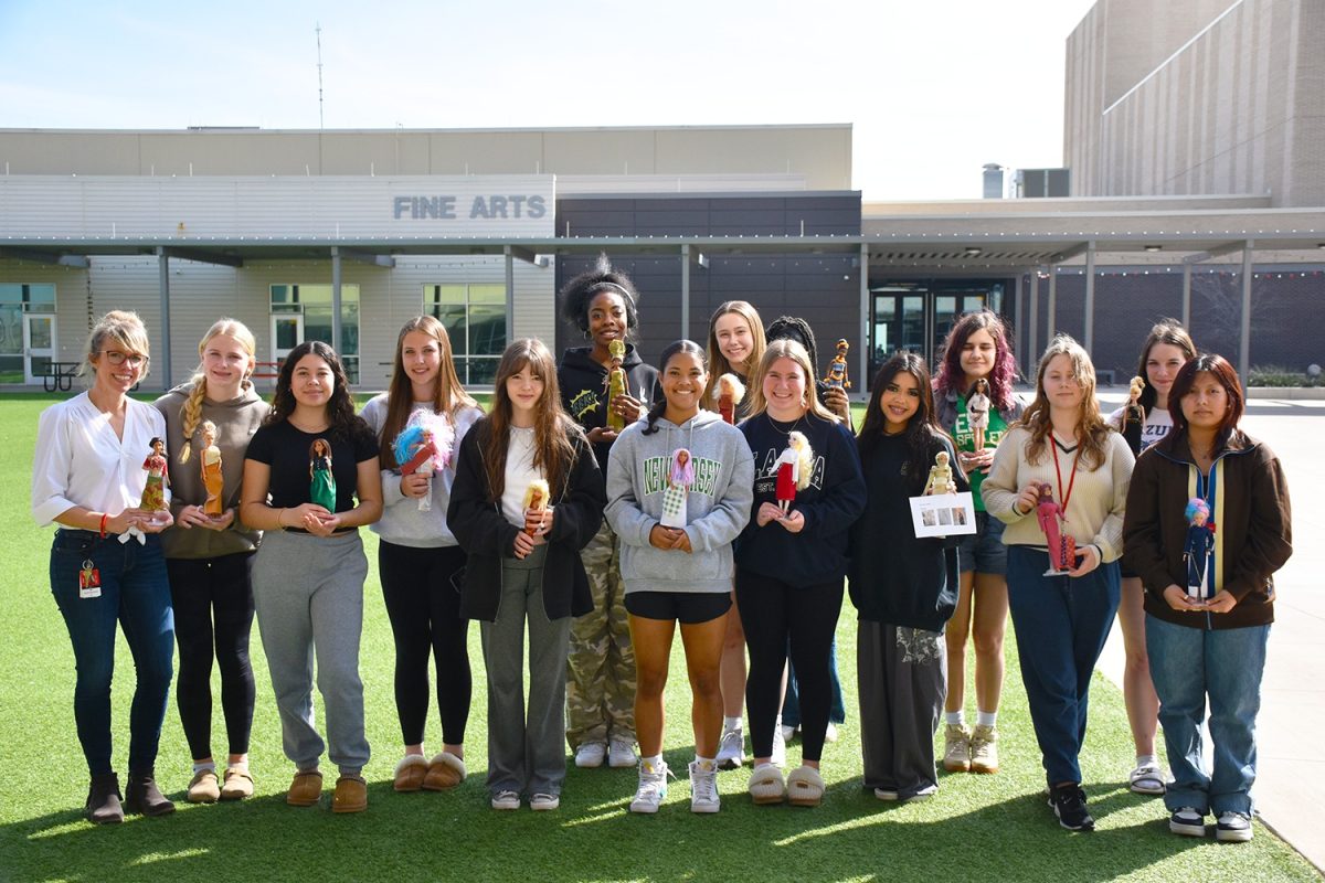One of the Fashion Design classes poses for a photo with their multicuturally dressed Barbies.