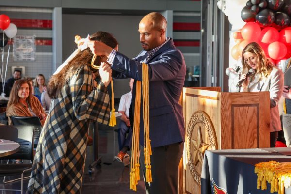 Assistant Principal David Moliere drapes a gold cord over one of the graduating seniors in the Top 10% at the first-ever Academic Banquet on April 29.