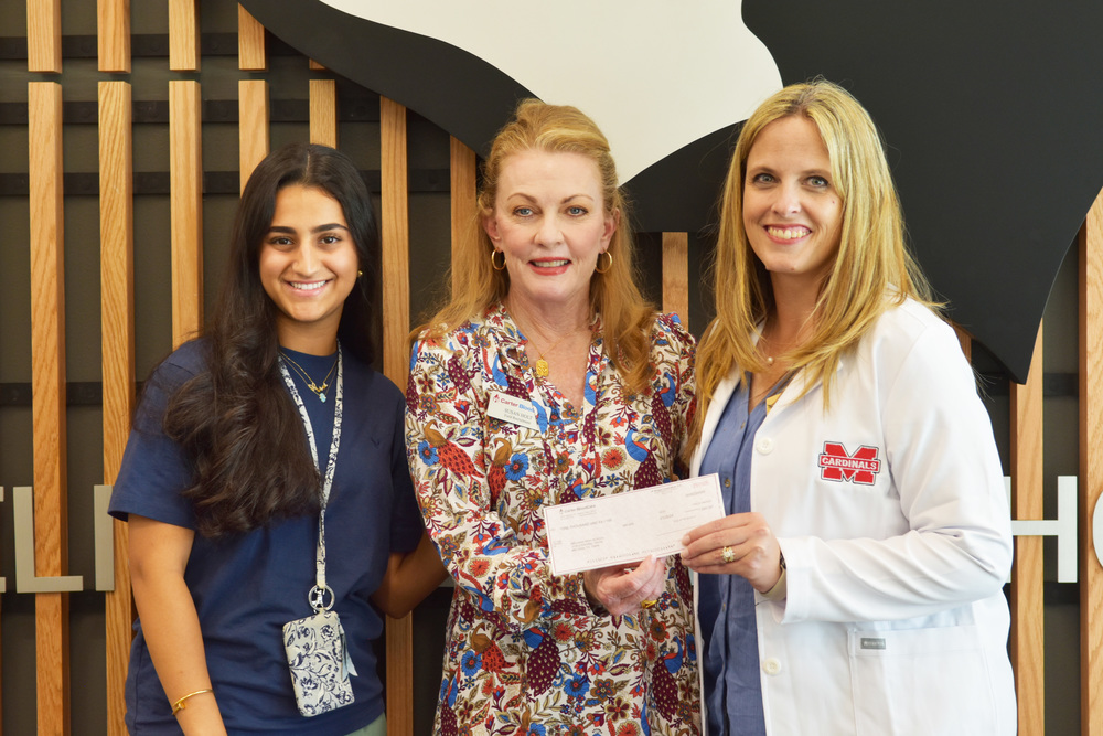 Senior Layan Alwazzan, president of HOSA, along with CTE & Health Coordinator Hallie Venner accept a $1,000 donation from Carter BloodCare. 