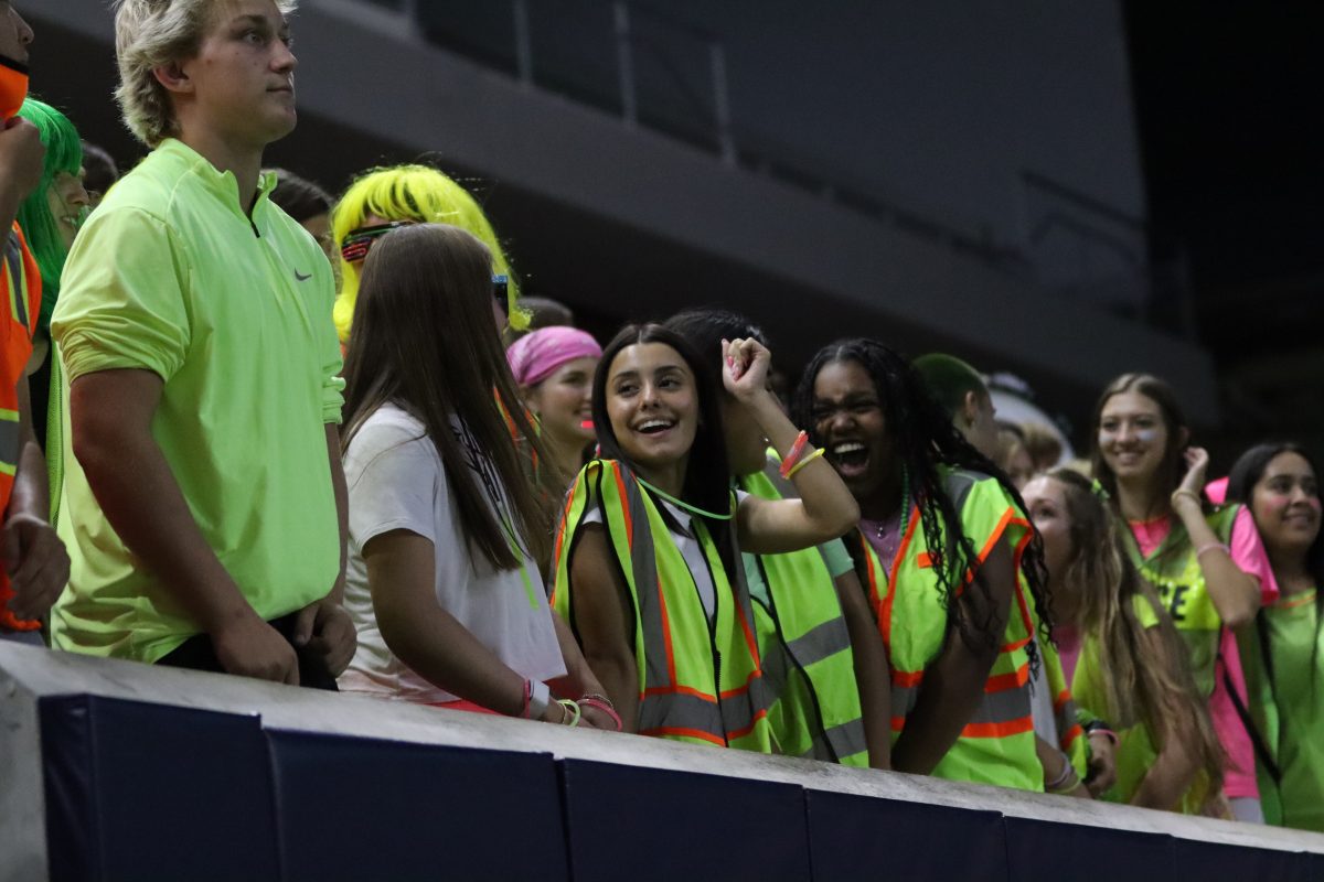 Students wear neon to support the Cardinals at the varsity football game against Frisco held in the Ford Center at The Star on Sept. 5. The Cardinals won, 55-13.