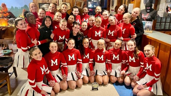 Varsity cheer poses with their trophy after earning 2nd place at the UCA regional competition on Nov. 10, qualifying them for national competition at Walt Disney World in February 2025.