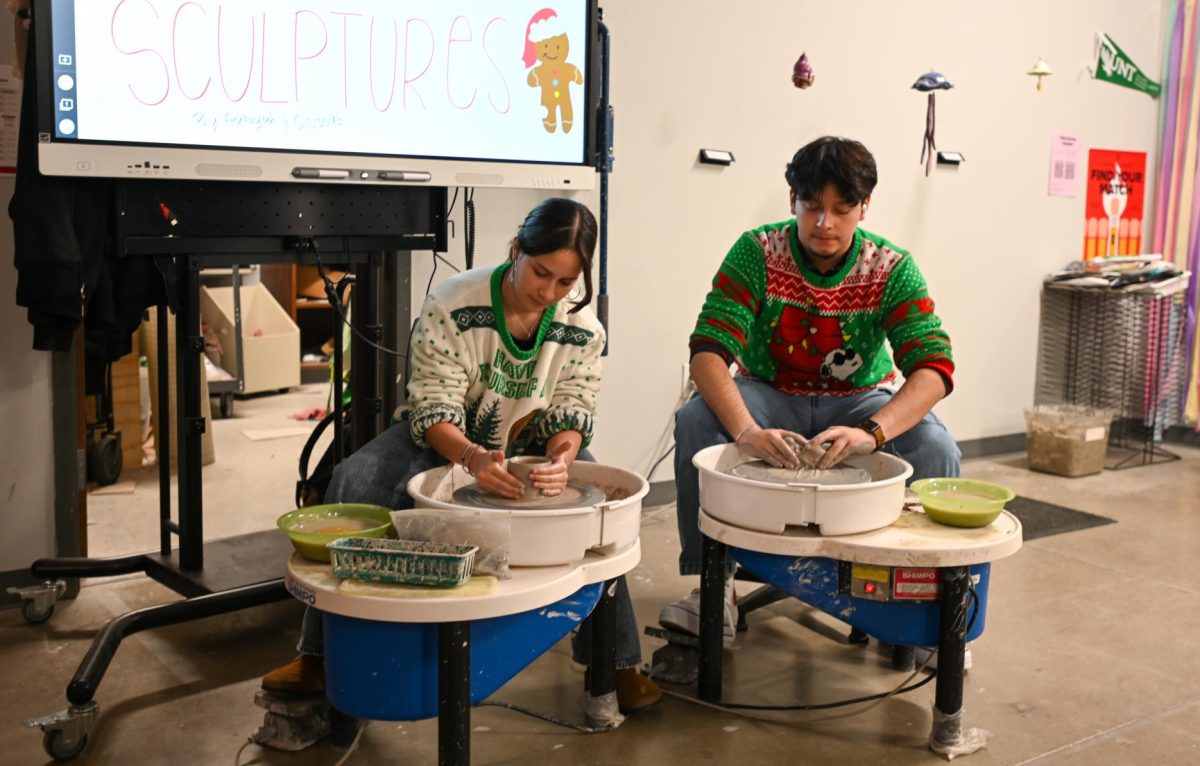 Two senior art students demonstrate how to use the pottery wheels at the Heart for the Arts festival held Dec. 10. The community gathered for arts and crafts and performances from K-12 students. The Chamber of Commerce's annual holiday parade followed the festival.