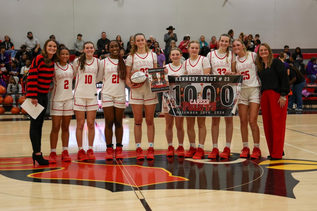 The varsity girls basketball team celebrates senior Kennedy Stout's 1,000 Career Points, which was achieved on Dec. 10, 2024, during the game against Greenville. Stout plans to continue playing basketball for Harding University.