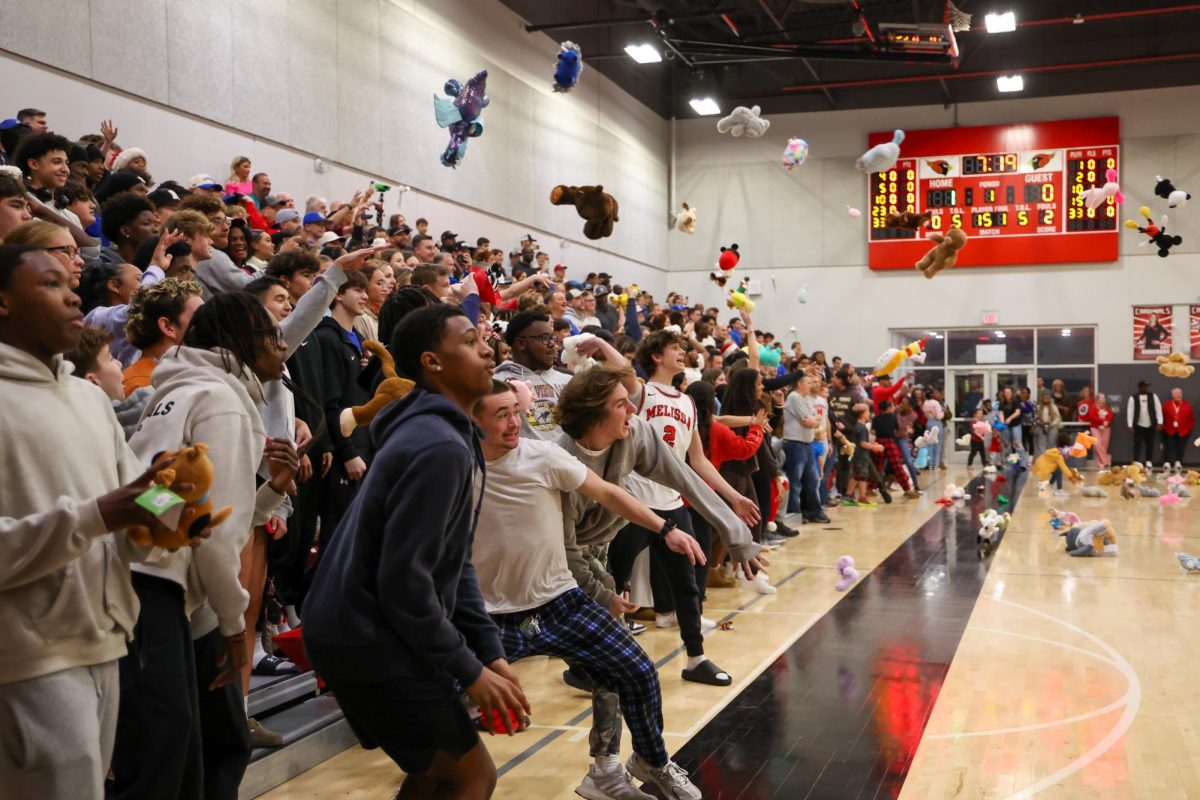 Students and fans toss teddy bears onto the basketball court as soon as the varsity boys scored a point in the home game against Anna on Dec. 17. The Cardinals donated more than 350 stuffed animals to support the Collin County Children’s Advocacy Center, spreading holiday cheer to children in need. The Cardinals also won the game 59-54.