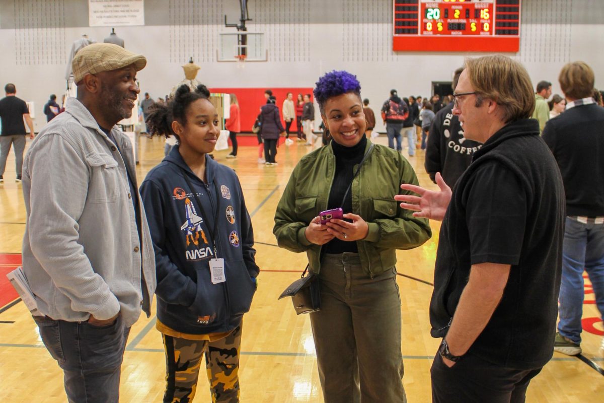 CTE Animation teacher Dustin Clark visits with a family during the Academic Expo held on Jan. 15. The expo is designed to help incoming 8th graders and current 9th-11th graders with course selections for the next school year.